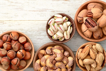 multiple roasted nuts on the wooden board, top view