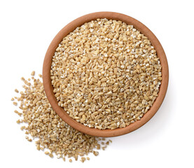 raw steel cut oats in the wooden plate, isolated on the white background, top view