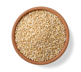 raw steel cut oats in the wooden plate, isolated on the white background, top view