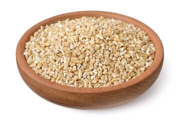 raw steel cut oats in the wooden plate, isolated on the white background