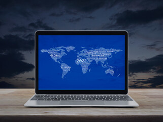 Start up 2022 business icon with global words world map with modern laptop computer on wooden table over sunset sky, Happy new year 2022 global business start up online concept, Elements of this image