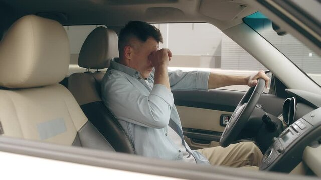 Tired taxi driver yawning, sitting in the car, feeling sleepy, urban lifestyle