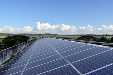 Photovoltaic roof with reflection of the Sun and clouds on the surface.