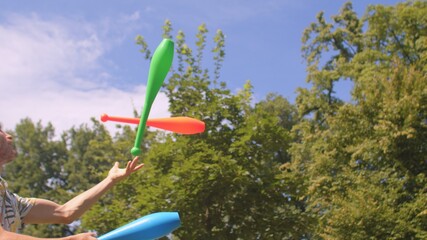 A young guy programmer actively spends time during a work break. Healthy hobbies. Juggling with...