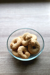 Bowl of biscuits on wooden table. Selective focus.