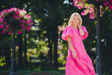 Photo portrait elder blonde woman walking on the street smiling enjoying sunny weather in summer