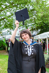 Young female student celebrating graduation. England