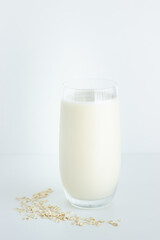 Close up of one glass of oat milk isolated on white background with copy space; vegan option; sustainable lifestyle; eco friendly 
