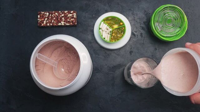 Cinemagraph, pouring shaken chocolate whey protein drink or a smoothie into a glass, seamless loop motion