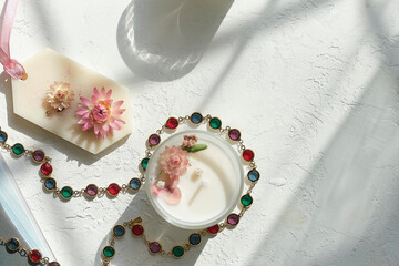 Handmade sachets and homemade candles with Pink and red dried flowers. Flat lay on grey textured table