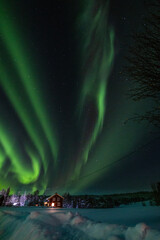aurora boreal de noche estrellada y fondo de nieve y casas - obrazy, fototapety, plakaty