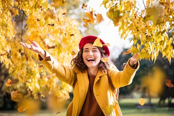 Poster Young playful woman playing with leaves in autumn © Rido