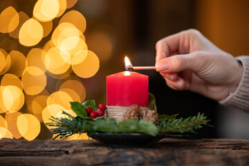Woman lighting christmas advent candle