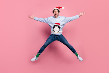 Photo of attractive funny young man dressed blue christmas pullover jumping like star smiling isolated pink color background