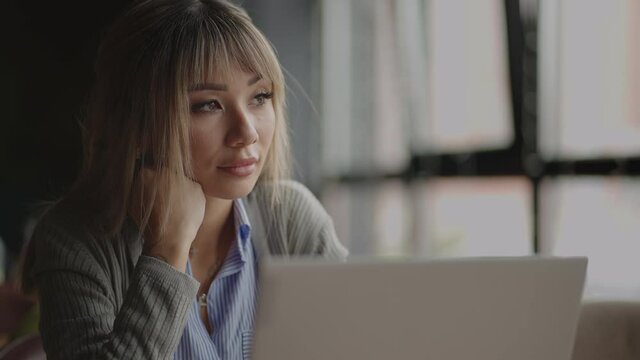 A young Asian woman misses looking at her laptop. portrait of a tired Asian student
