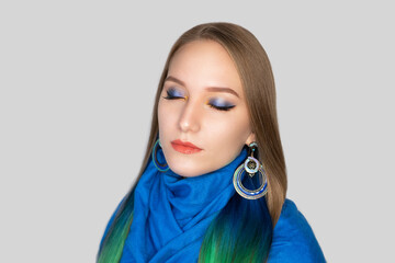 New creative make-up, conceptual art idea. blue shadows, vivid colors graphic shapes lines, cosmetics, massive round jewellery. close-up photo. skin painting artistic. perfect straight golden hair