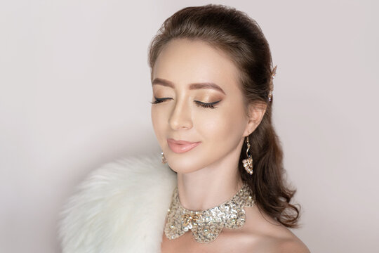 Beautiful woman skincare concept. Bright makeup with arrows shades shadows sequins. Evening hairstyle brunette courly hair, jewel. background horizontal gray banner. New big necklace massive jewellery