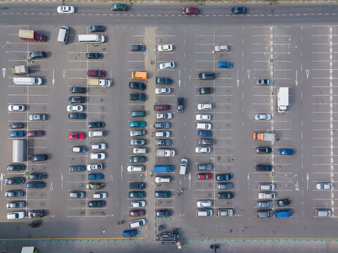Drone view of a large car parking lot on a sunny summer day, horizontal car parking