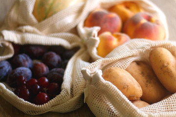 Reusable mesh bag filled with fresh fruit and vegetables. Selective focus.