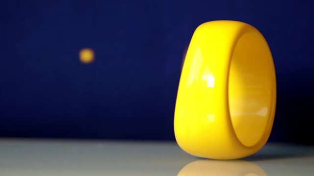 Yellow bracelet on a glass surface. Colourful glass beads are falling down. Recorded with the sound