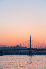 トルコ　イスタンブールの金角湾にかかる新市街と旧市街をつなぐ橋と夕焼けでオレンジに染まった空