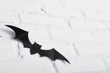 paper cut bat on white brick wall