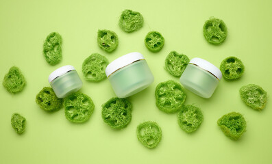 empty white jar for cosmetics on a green background. Packaging for cream, gel, serum, advertising and product promotion. Mock up, top view