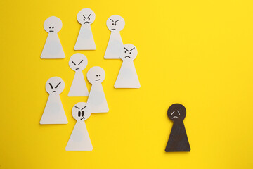 Black paper pawn standing out from white ones on yellow background, flat lay. Concept of racism