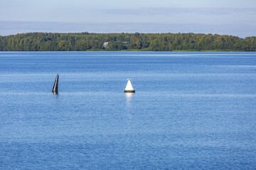 Calm river water surface and iron navigation buoy