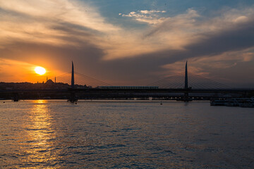 Fototapeta na wymiar トルコ　イスタンブールの金角湾にかかるアタチュルク橋と夕焼けでオレンジに染まった空