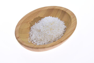 Coconut shavings in a wooden bowl against a white background. Food.