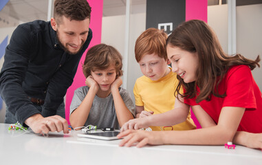 Creative children with teacher studying robotics