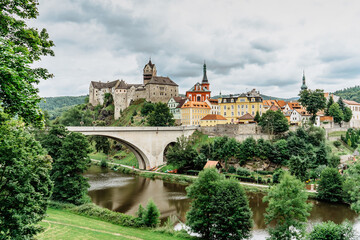 Obraz premium Panoramic view of famous medieval town of Loket,Elbogen, with colorful houses and stone castle above river,Czech Republic.Historical city centre is national monument.Travel architecture background