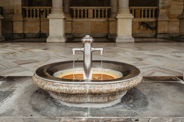 Healing water from hot mineral spring in famous spa town Karlovy Vary, Czech Republic.Natural therapy of health diseases.Treatment therapeutic concept.Drinking water from iron fountain.