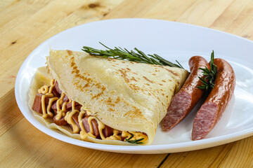 Pancake with sliced sausage and mustard