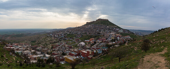 Fototapeta na wymiar トルコ　マルディンの山の斜面に広がる旧市街の街並みと山頂に立つマルディン城