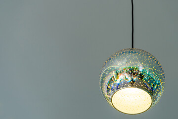 Modern chandelier in the shape of a ball on a gray background. Copy space