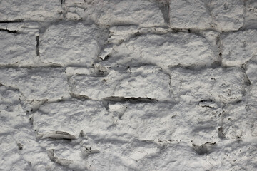 Fragment of the wall from natural stone painted with lime