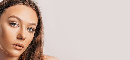 Obraz premium Beautiful young girl smiling and posing looking at the camera on a white isolated background with mockup. Positive brunette woman. Kind look. Beauty face