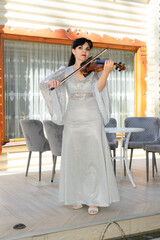 A violinist in an evening dress plays the violin