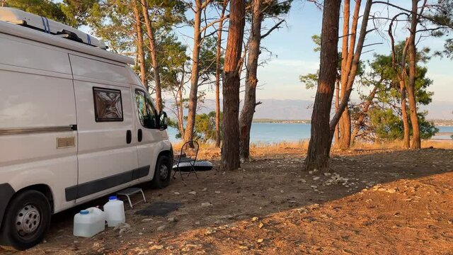 Warm orange light over wild camping spot and a camper van in Zadar region, Croatia.