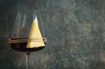 Glass Of Red Wine and Cheese on stone background