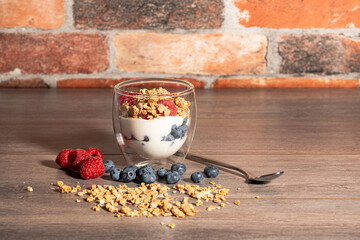 raspberries with blueberries and cereals in a glass bowl -3