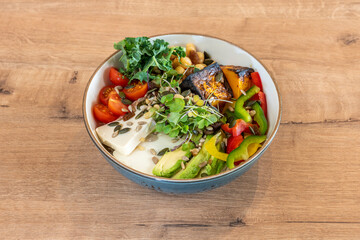 Poke bowl with pumpkin and sunflower seeds, ripe avocado, fresh cheese, chopped bell pepper, cherry tomatoes, kale leaves, cooked chickpeas and roasted sweet potato