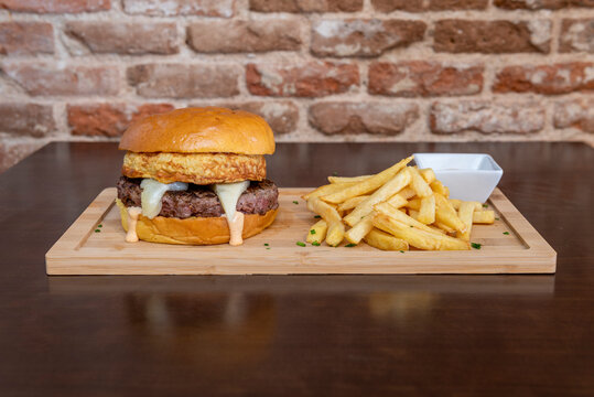 burger with beef, mini Spanish omelette, Manchego cheese, salsa, chips and chives