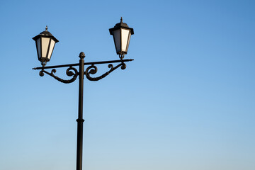 Fototapeta na wymiar Daytime vintage street lamp post lantern lanterns in park with sky and clouds