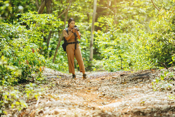 Biologist or botanist recording information, photography about tropical plants in forest. The concept of hiking to study and research botanical gardens by searching for information.