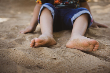 Obraz na płótnie Canvas Child playing with sand in the park. Fun in the park. Son playing in the sand. Child smiling. Playing with sand. 