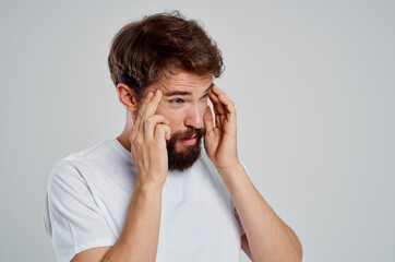 man holding his head pain stress emotions light background