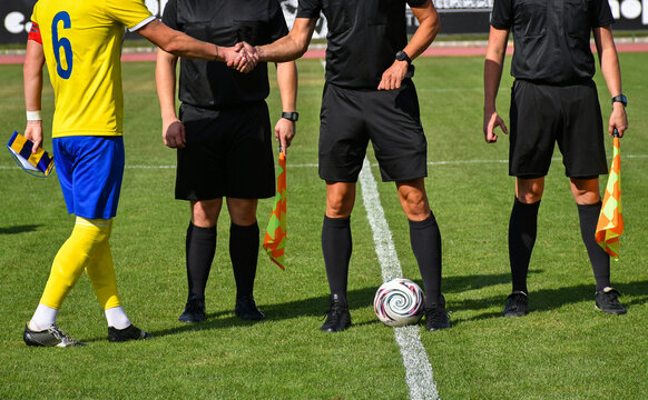 Soccer referees and a player handshake
